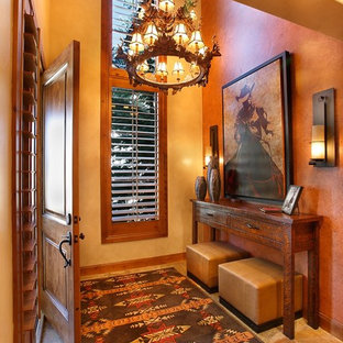 Exemple d'un hall d'entrée sud-ouest américain de taille moyenne avec un mur jaune, un sol en travertin, une porte simple et une porte en bois brun.