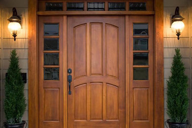 Modelo de puerta principal tradicional grande con paredes marrones, puerta simple y puerta de madera oscura
