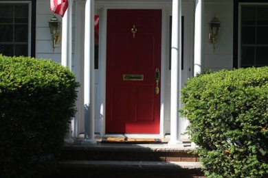 Ejemplo de puerta principal clásica grande con puerta simple y puerta roja