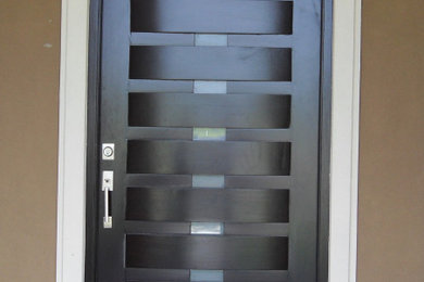 Example of a mid-sized minimalist ceramic tile and multicolored floor entryway design in Other with beige walls and a black front door