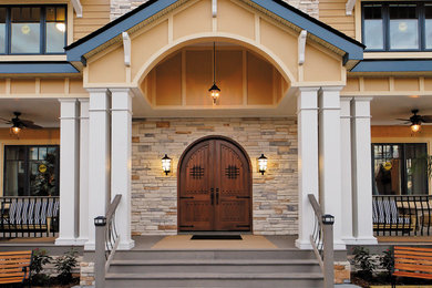 Ejemplo de puerta principal tradicional grande con paredes multicolor, puerta simple y puerta de madera en tonos medios