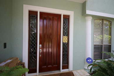 Modelo de puerta principal actual grande con paredes verdes, suelo de piedra caliza, puerta simple y puerta de madera oscura