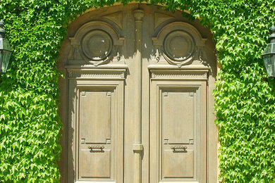 Modelo de puerta principal tradicional grande con puerta doble y puerta de madera clara