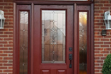 Imagen de puerta principal de estilo americano de tamaño medio con puerta simple, puerta roja, paredes rojas y suelo de cemento