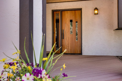 На фото: входная дверь среднего размера в современном стиле с одностворчатой входной дверью и входной дверью из дерева среднего тона