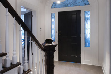 Пример оригинального дизайна: большое фойе в современном стиле с белыми стенами, полом из керамической плитки, одностворчатой входной дверью, черной входной дверью и разноцветным полом