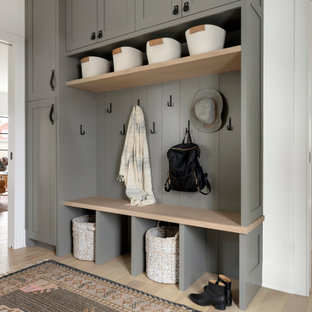 Immagine di un ingresso con anticamera classico con pareti bianche, parquet chiaro e pavimento beige