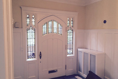 トロントにある中くらいなトラディショナルスタイルのおしゃれな玄関ドア (ベージュの壁、白いドア、茶色い床) の写真