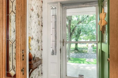 Inspiration for a small timeless porcelain tile and wallpaper entryway remodel in Omaha with a green front door