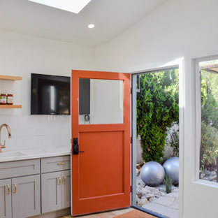 Diseño de puerta principal clásica, pequeña, con paredes blancas, suelo laminado, puerta simple, puerta naranja y suelo marrón