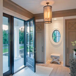 Immagine di un ingresso chic con pareti bianche, parquet chiaro, una porta singola e una porta in vetro