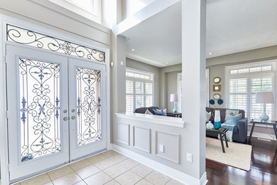 Modelo de puerta principal clásica renovada de tamaño medio con paredes grises, suelo de baldosas de cerámica, puerta doble, puerta de vidrio y suelo beige