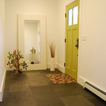 Eclectic foyer with slate floor and bright green door