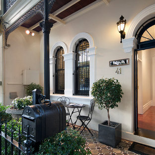 Photo of a victorian front door in Newcastle - Maitland with beige walls, a single front door, a black front door and brown floor.