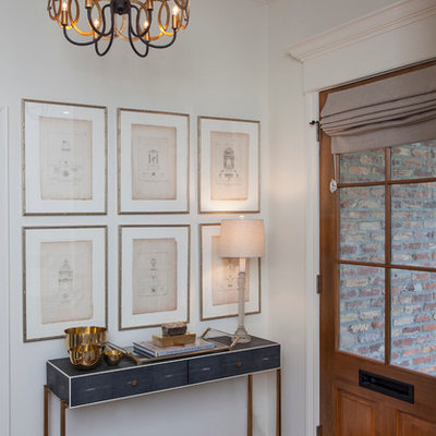 Example of a transitional dark wood floor entryway design in New Orleans with white walls and a medium wood front door