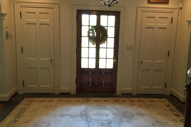 Foto de puerta principal clásica renovada de tamaño medio con paredes beige, suelo de madera oscura, puerta simple y puerta roja
