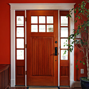 Foto de puerta principal tradicional, de tamaño medio, con paredes rojas, puerta simple, puerta de madera en tonos medios y suelo de madera en tonos medios