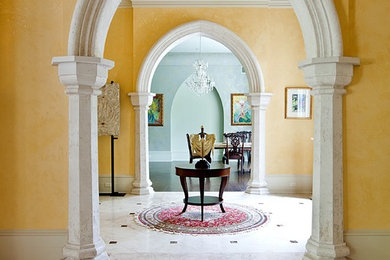 Inspiration for a mediterranean travertine floor foyer remodel in New Orleans with yellow walls