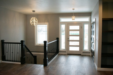 Imagen de distribuidor moderno grande con paredes grises, suelo vinílico, puerta simple, puerta blanca y suelo marrón