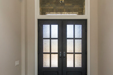 シャーロットにあるおしゃれな玄関 (ベージュの壁、濃色無垢フローリング、黒いドア) の写真