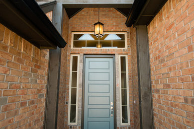 Ejemplo de puerta principal tradicional renovada de tamaño medio con suelo de cemento, puerta simple y puerta azul