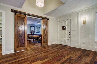 Entryway - large rustic dark wood floor entryway idea in Kansas City with white walls and a white front door