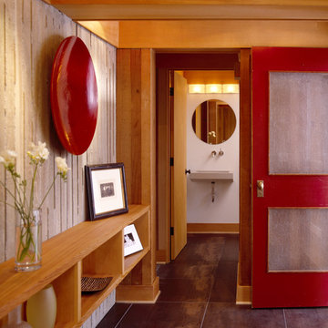 Entry with tile floors, board formed concrete and red door