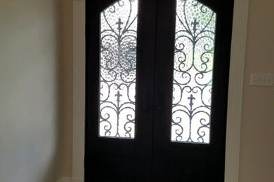 Diseño de puerta principal clásica de tamaño medio con paredes beige, suelo de madera oscura, puerta doble, puerta negra y suelo marrón