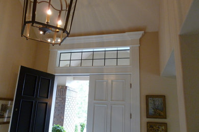 Imagen de puerta principal tradicional de tamaño medio con paredes beige, puerta doble y puerta blanca
