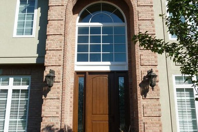 シカゴにある広いトランジショナルスタイルのおしゃれな玄関ドア (木目調のドア) の写真