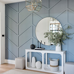 Immagine di un ingresso tradizionale con pareti blu, parquet chiaro, una porta singola e una porta in vetro