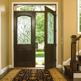 Immagine di una porta d'ingresso stile rurale di medie dimensioni con pareti beige, una porta a due ante e una porta in legno scuro