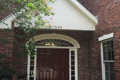 Example of a mid-sized classic double front door design in New Orleans with a dark wood front door