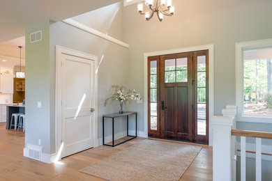 グランドラピッズにある中くらいなトラディショナルスタイルのおしゃれな玄関ドア (グレーの壁、淡色無垢フローリング、濃色木目調のドア、ベージュの床) の写真