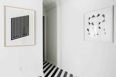 ニューヨークにある高級な中くらいなトランジショナルスタイルのおしゃれな玄関ロビー (白い壁、大理石の床、黒い床、板張り天井) の写真