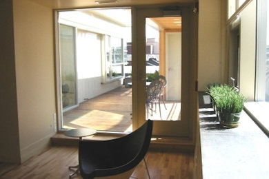 Ejemplo de puerta principal de tamaño medio con paredes beige, suelo de madera clara y puerta simple