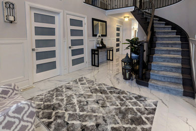 トロントにある高級な中くらいなトランジショナルスタイルのおしゃれな玄関ロビー (グレーの壁、大理石の床、濃色木目調のドア、白い床) の写真