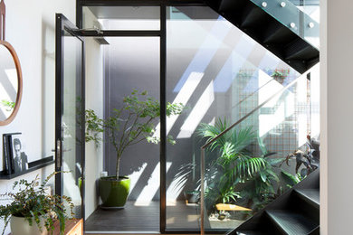 Mittelgroße Moderne Haustür mit braunem Holzboden, Einzeltür, weißer Wandfarbe, beigem Boden und Treppe in Melbourne