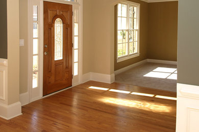 Inspiration for a mid-sized medium tone wood floor entryway remodel in Raleigh with beige walls and a medium wood front door
