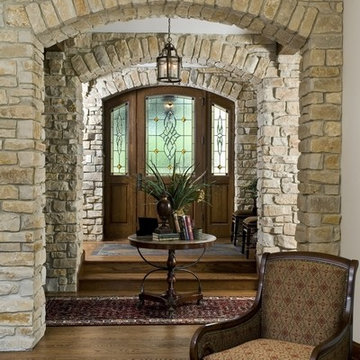 Foyer Featuring Arched Stone Openings and White Oak Leaded Glass Front Door