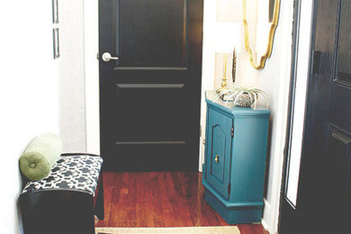 Immagine di un piccolo ingresso chic con pareti nere, parquet scuro, una porta singola e una porta nera