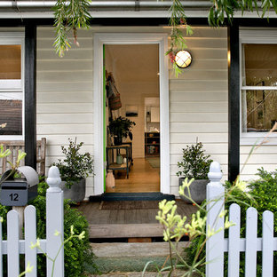 Traditional front door in Sydney with white walls, medium hardwood floors, a single front door and brown floor.