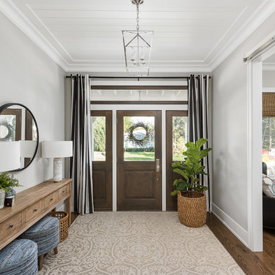 Example of a large transitional brown floor and dark wood floor entryway design in Chicago with gray walls and a dark wood front door