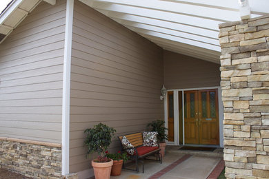 Ejemplo de puerta principal retro de tamaño medio con paredes beige, suelo de cemento, puerta doble, puerta de madera clara y suelo gris