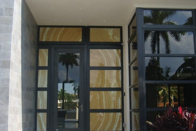 Imagen de puerta principal actual de tamaño medio con paredes blancas, suelo de cemento, puerta simple y puerta de vidrio