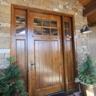 Foto di una grande porta d'ingresso american style con una porta singola, una porta in legno bruno e pavimento in cemento