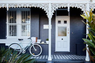 Ejemplo de puerta principal tradicional de tamaño medio con paredes negras, suelo de baldosas de porcelana, puerta simple, puerta blanca y suelo negro