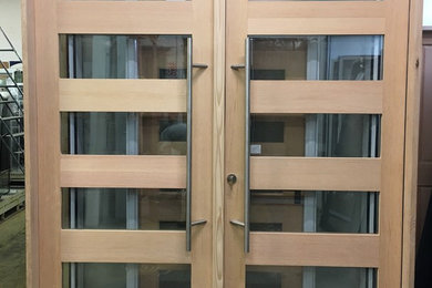 Foto de puerta principal de estilo americano con puerta doble y puerta de madera clara