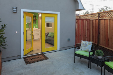 サンフランシスコにある北欧スタイルのおしゃれな玄関ドア (グレーの壁、ラミネートの床、黄色いドア、茶色い床) の写真