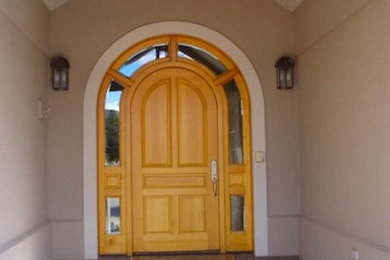 Example of an entryway design in Denver with a light wood front door